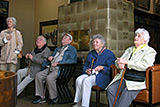 Fnf Teilnehmerinnen und Teilnehmer des Seniorenausflugs beim Betrachten von Bildern.