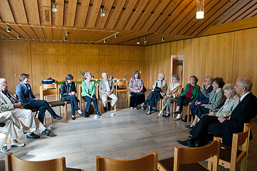 Blick in den groen Gemeinderaum, wo Teilnehmerinnen und Teilnehmer des Predigtnachgesprchs auf kreisfrmig angeordneten Sthlen sitzen.