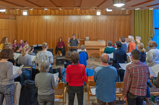 Blick in den groen Gemeinderaum der Trinitatiskirche, wo die Choristen und die Dirigentin bei der Probe zu sehen sind.