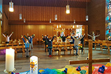 Blick von der Rckseite des Altars in den Kirchenraum, wo die Kinder mit Abstand und Masken den Kinderweltgebetstag feiern.