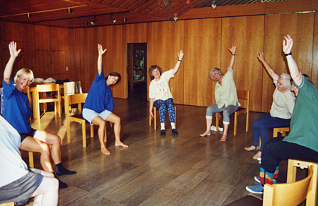 Foto, das den Blick in den großen Gemeinderaum zeigt, in dem Teilnehmerinnen der Entspannungsgymnastik aktiv sind