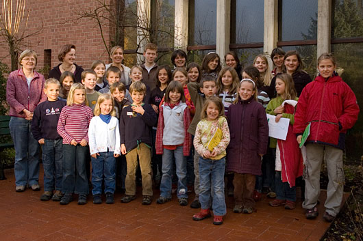 Gruppenbild mit den Kindern und allen Helferinnen neben dem Eingang zur Kirche