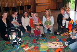 Blick in den großen Gemeinderaum, wo Mütter mit ihren Kindern einen Halbkreis bilden