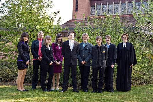 Die Konfirmanden 2009 und Pfarrerin Bettina Mohr vor der Westseite der Trinitatiskirche
