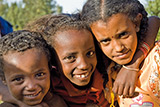 Drei äthiopische Kinder blicken in die Kamera.