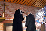 Dr. Bernhard Orlich empfängt die Ehrung durch Dekan Hanns Baumeister vor dem Altar der Trinitatiskirche.