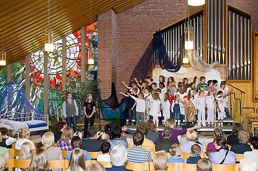 Singende Kinder auf der Bühne am Gemeindefest, die ausnahmsweise vor der großen Orgel aufgebaut war.
