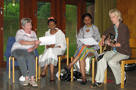 Die beiden weiblichen Mitglieder der äthiopischen Delegation 2010 und weitere Besucherinnen der Veranstaltung beim gemeinsamen Singen im großen Gemeinderaum der Trinitatiskirche.