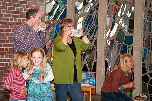 Zwei erwachsene Teilnehmer und zwei Kinder im Altarraum der Trinitatiskirche tragen durch Kammblasen und Bauchtrommeln ein Lied vor, das die eigene Gruppe erraten muss.