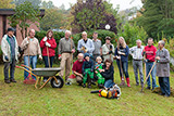 Gruppenfoto mit den Teilnehmerinnen und Teilnehmern der Gartenaktion vor der Kirche.