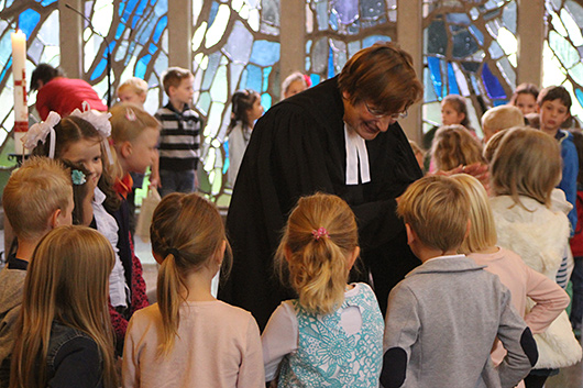 Pfarrerin Mohr segnet die im Altarraum der Trinitatiskirche im Kreis aufgestellten angehenden Schulkinder.