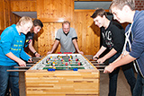Vier Jugendliche spielen Tischfußball im Untergeschoss der Trinitatiskirche.