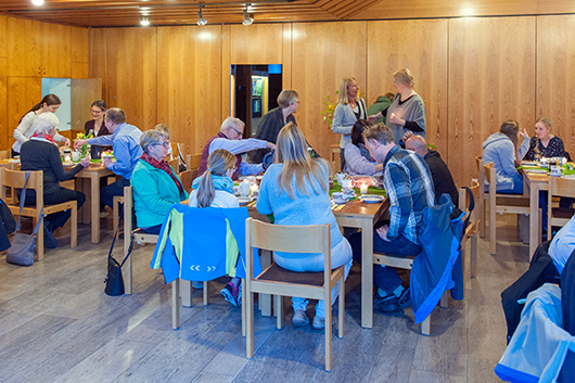 Im großen Gemeinderaum haben die Besucherinnen und Besucher des Osternachtsgottesdienst zum Frühstück Platz an den Tischen genommen.