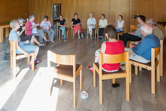 Blick in den Gemeinderaum der Trinitatiskirche, wo die Teilnehmerinnen und Teilnehmer des Predigtnachgesprächs in einer Runde sitzen und diskutieren.