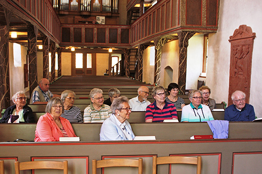Blick in die Ebsdorfer Kirche, wo die Teilnehmerinnen und Teilnehmer des Seniorenausflugs gespannt den Ausführungen der Referenten zuhören.