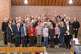 Rund 45 Mitwirkende haben sich vor dem Altar der Trinitatiskirche zum Gruppenbild nach dem Konzertgottesdienst aufgestellt.