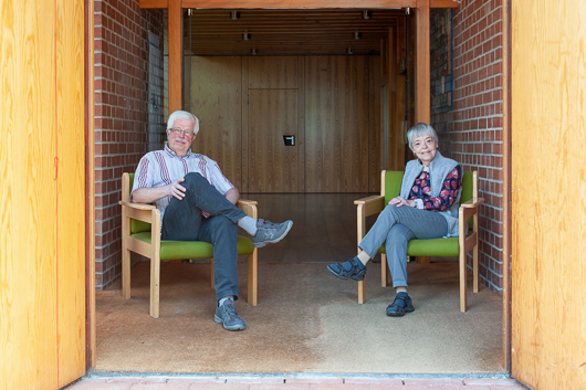 Die beiden Interviewten sitzen auf Sesseln im Eingangsbereich der Trinitatiskirche.