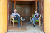 Die beiden Interviewten sitzen auf Sesseln im Eingangsbereich der Trinitatiskirche.