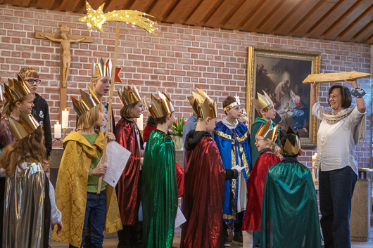 Ein Teil der Sternsinger führt im Altarraum der Trinitatiskirche vor, wie ein Besuch abläuft.
