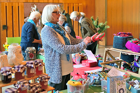 Ein Mitglied des Kreativteams aus Kirchhain präsentiert selbst hergestellte Produkte im Foyer der Trinitatiskirche.