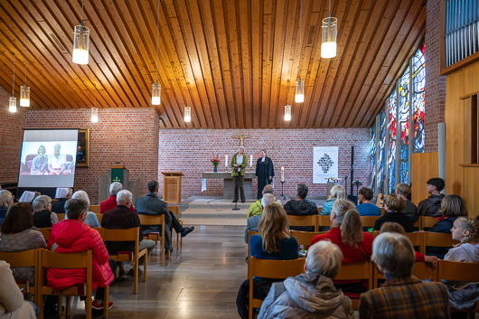Blick von hinten in die fast bis auf den letzten Platz gefllte Kirche, in der Pfarrerin Bettina Mohr und Pfarrerin im Ruhestand Margarete Deist zu sehen sind.