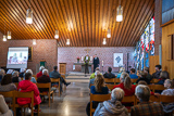 Blick von hinten in die fast bis auf den letzten Platz gefllte Kirche, in der Pfarrerin Bettina Mohr und Pfarrerin im Ruhestand Margarete Deist zu sehen sind.