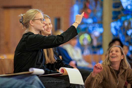 Das Foto zeigt drei Mitglieder des Vorbereitungsteams, die Regieanweisungen geben.