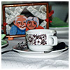 Kaffeetasse mit einem gerahmten Bild im Hintergrund, das ein Seniorenpaar zeigt
